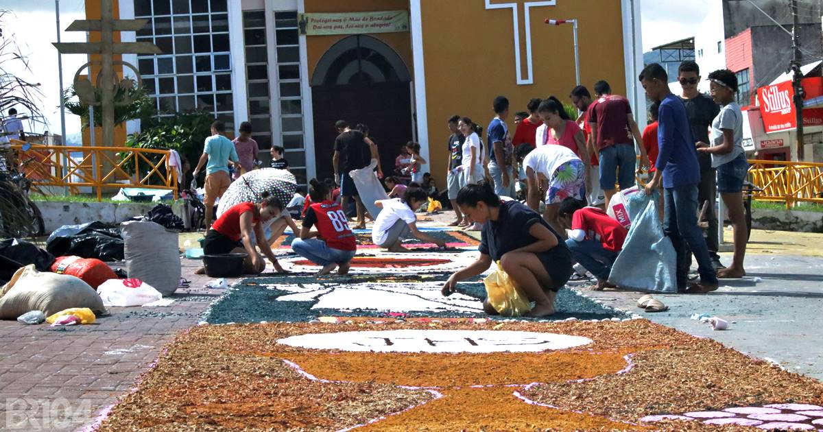 Grupos de católicos trabalham na produção de tapete para ornamentar ruas da cidade para a passagem de procissão — © Gustavo Lopes/BR104