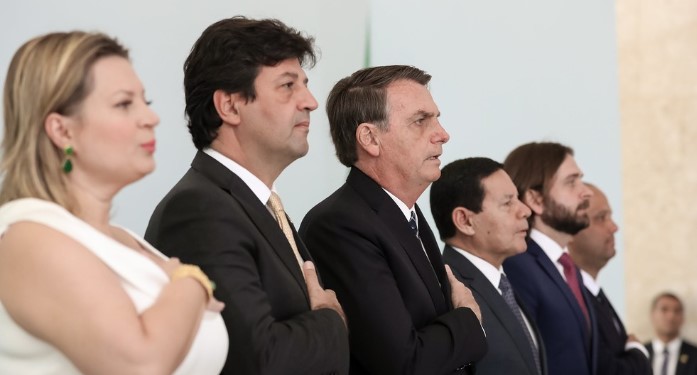 Bolsonaro e outras autoridades durante a execução do hino nacional na cerimônia de lançamento do programa Médico pelo Brasil  — ©  Marcos Corrêa