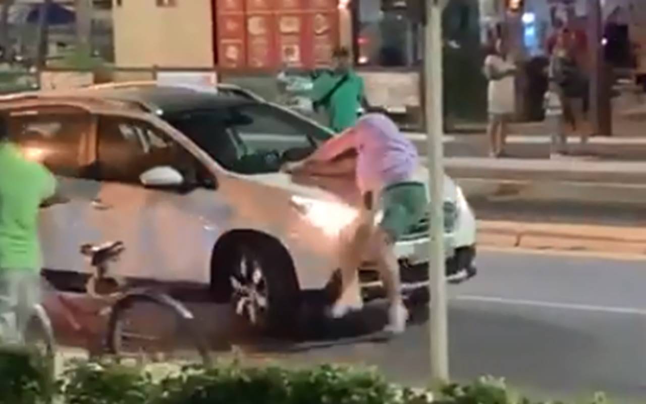 Homem pula em carro e é carregado durante briga de trânsito — © Reprodução/Vídeo
