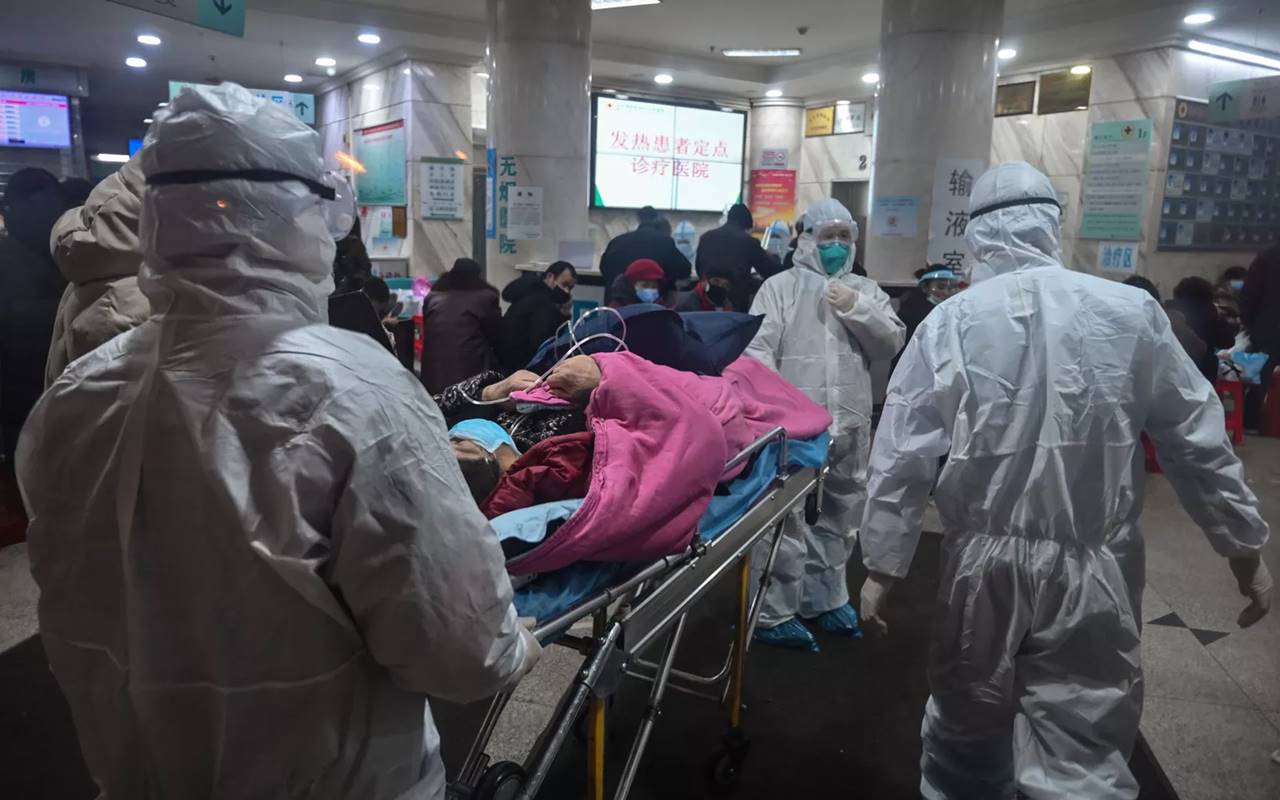 Equipe médica transporta paciente em hospital da Cruz Vemelha, em Wuhan, na China — © Hector Retamal/AFP