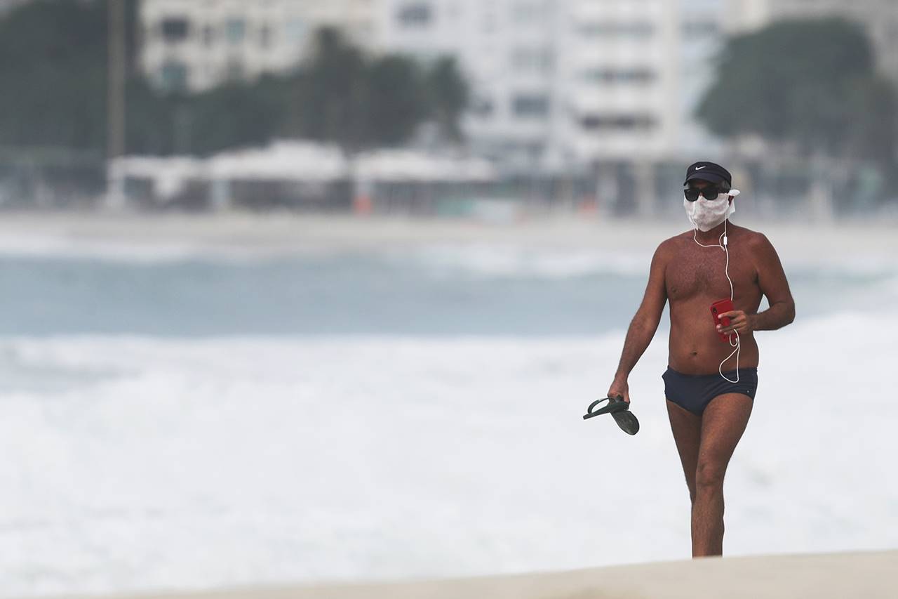 Homem na praia durante pandemia do novo coronavirus