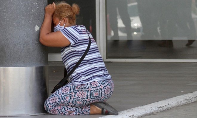 Mulher chorando a morte de um parente vítima de Covid-19