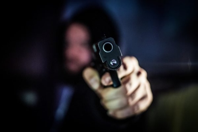 Homem encapuzado segurando revólver — © Ilustração