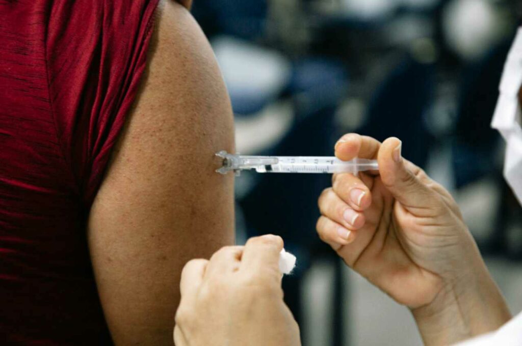 Profissional da saúde vacinando cidadão | © Assessoria