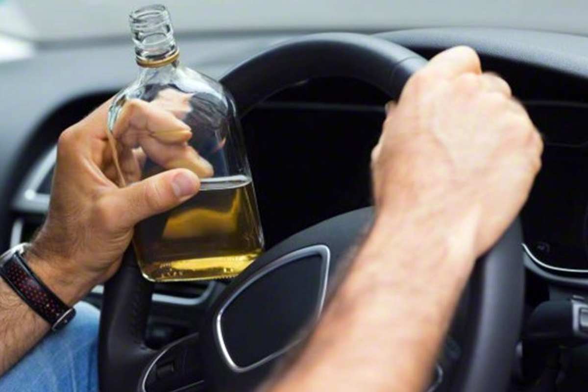 Homem com bebida alcoólica dirigindo carro | © Imagem meramente ilustrativa