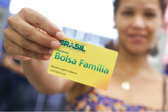 Mulher segurando cartão do programa Bolsa Família – © Rafael Zart