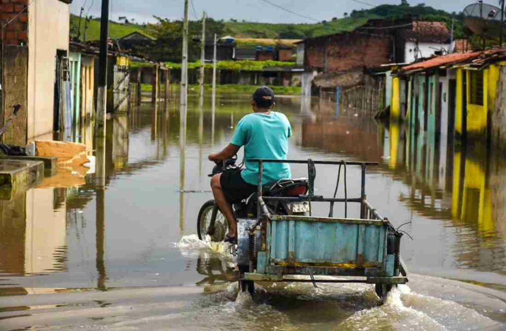 Chuvas recentes faz Riacho Bebiribe transbordar e alagar ruas da parte baixa de Murici