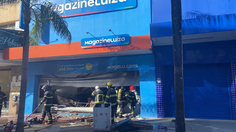 Bombeiros abrem porta de loja e tentam controlar as chamas, Maceió — Foto: Andrea Resende/TV Gazeta