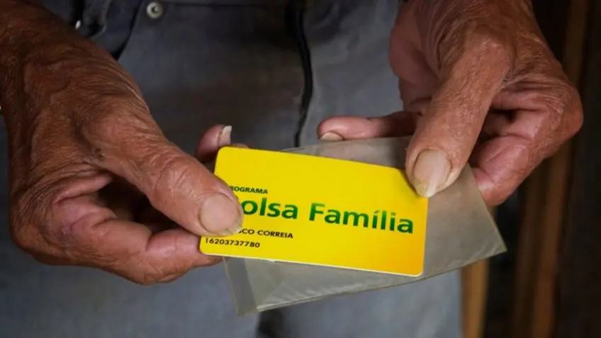 Homem segurando cartão do Bolsa Família - @Reprodução