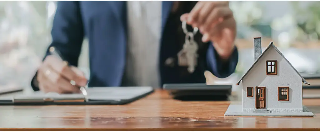 Homem segurando a chave de uma casa sobre documentos de IPTU - @Reprodução