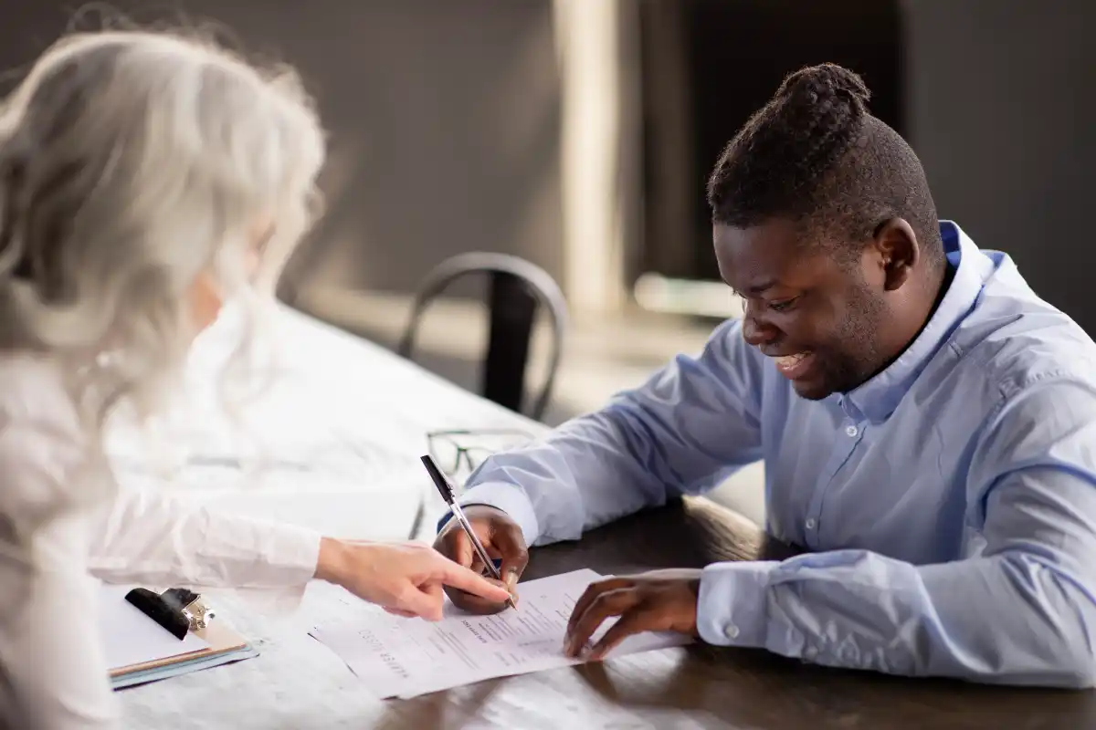 Homem assinando um documento com o RH - @Reprodução