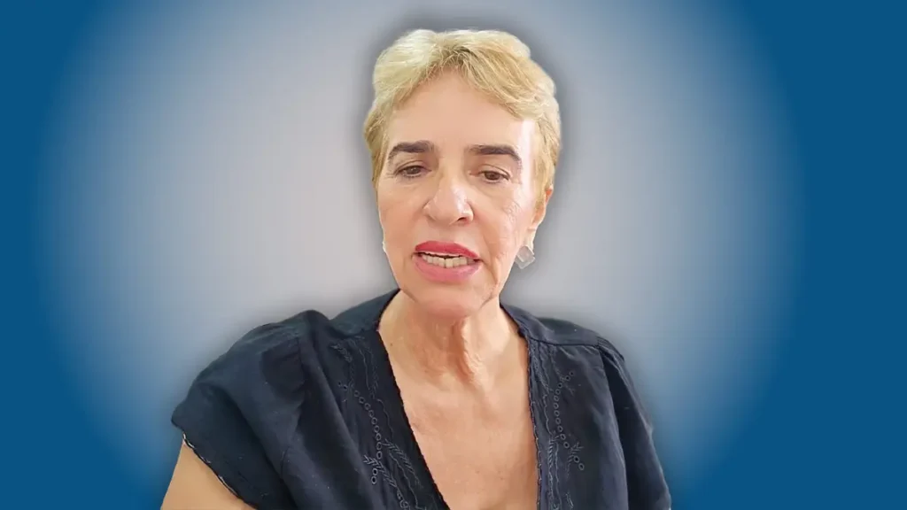 Eliane do Globo aparece em retrato falando para a câmera em ambiente interno com fundo desfocado