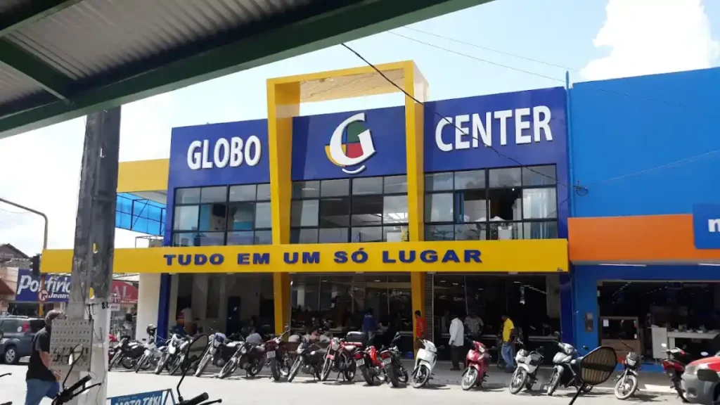 fachada da loja Globo Center com letreiro e slogan “Tudo em um só lugar” e motos estacionadas em frente ao prédio