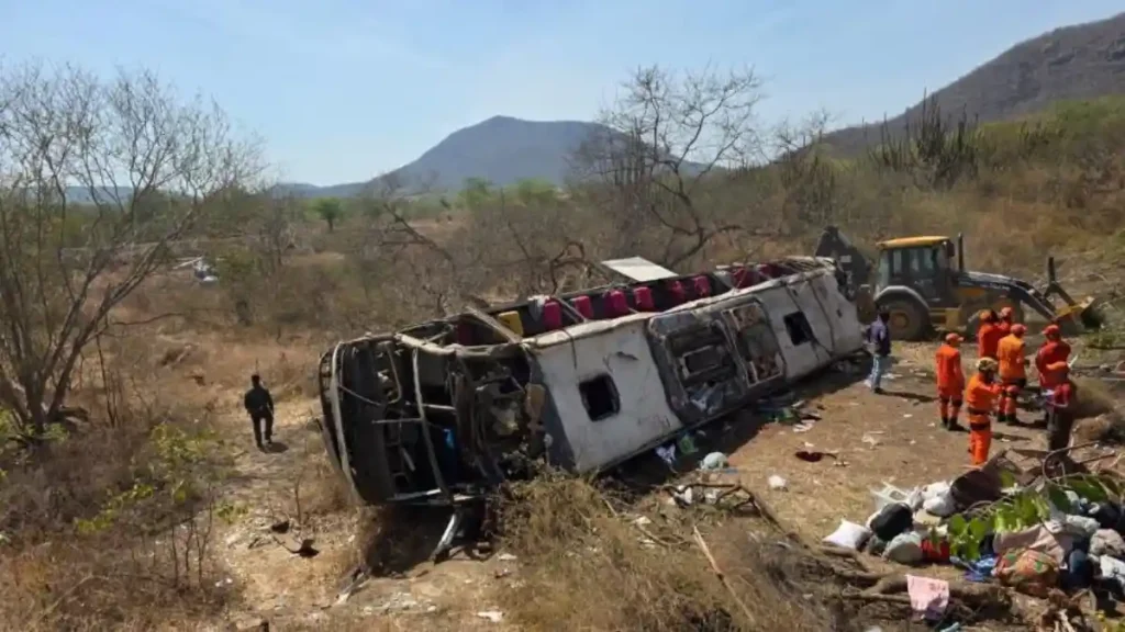 Ônibus de romeiros capotado fora da pista em área rural de Alagoas enquanto equipes de resgate atuam no local após acidente com ao menos 15 mortos