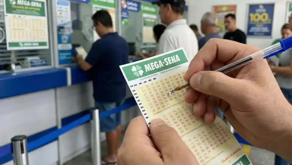Mão marca dezenas no volante da Mega-Sena com caneta dentro de lotérica da Caixa durante apuração do resultado do concurso 2970